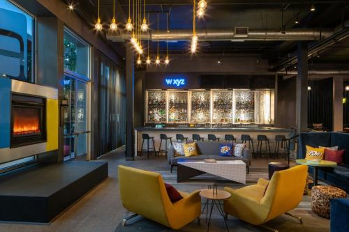 a lobby with chairs and a bar in the background at aloft Green Bay in Green Bay