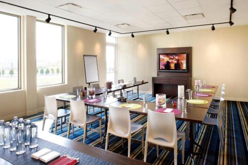a room with a long table and chairs and windows at aloft Green Bay in Green Bay