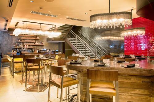 a restaurant with a bar with tables and chairs at Metropolitan at The 9, Autograph Collection in Cleveland