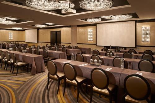 a conference room with tables and chairs and a screen at Metropolitan at The 9, Autograph Collection in Cleveland