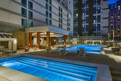 a pool with chairs and tables and a building at AC Hotel Nashville Downtown in Nashville