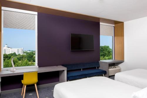 a hotel room with a bed and a tv at Aloft Charlotte Ballantyne in Charlotte