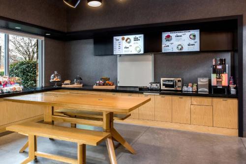 a kitchen with a wooden table and a counter at Aloft Charlotte Ballantyne in Charlotte
