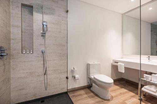 a bathroom with a shower and a toilet and a sink at AC Hotel by Marriott Bogota Zona T in Bogotá