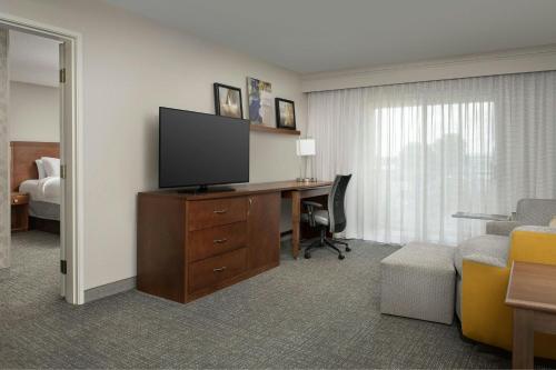 a hotel room with a desk with a television and a bed at Courtyard Chico in Chico