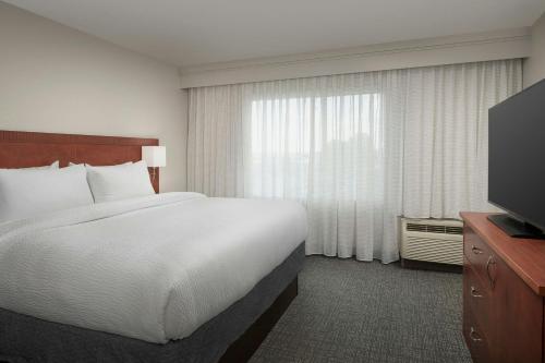 a hotel room with a bed and a television at Courtyard Chico in Chico