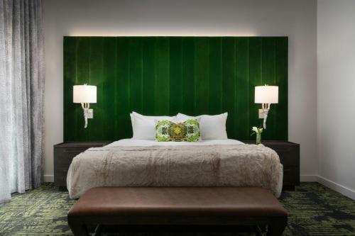 a bedroom with a large bed with a green wall at Grand Bohemian Lodge Greenville, Autograph Collection in Greenville