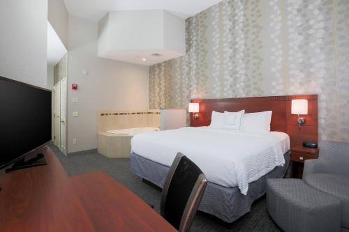 a hotel room with a bed and a bath tub at Courtyard Chico in Chico