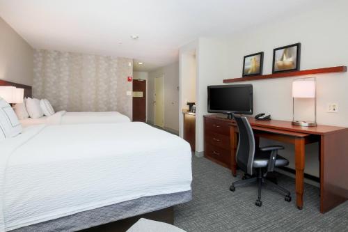 a hotel room with a bed and a desk with a computer at Courtyard Chico in Chico