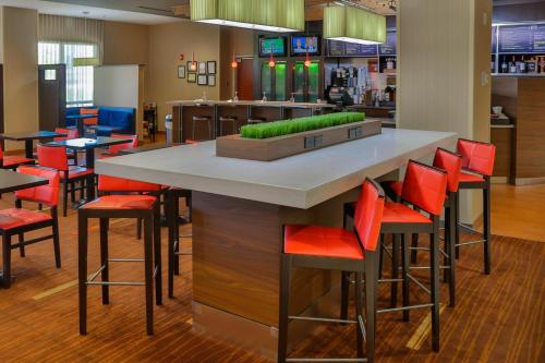 a bar in a restaurant with red bar stools at Courtyard Biloxi North/D'Iberville in Biloxi