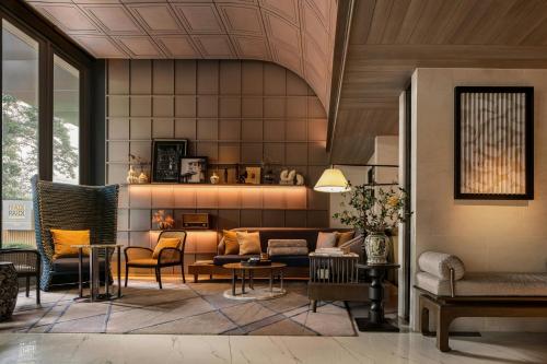a living room with a couch and chairs at Madi Paidi Bangkok, Autograph Collection in Bangkok