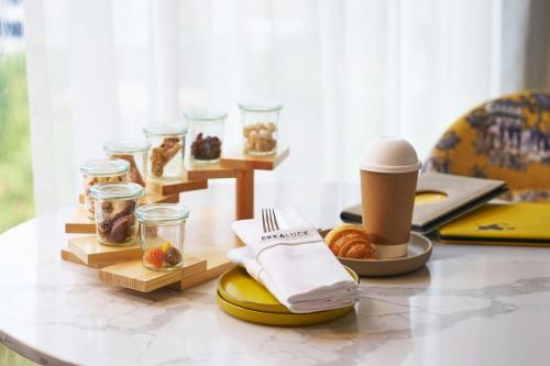 a table with a breakfast of pastries and a cup of coffee at Madi Paidi Bangkok, Autograph Collection in Bangkok