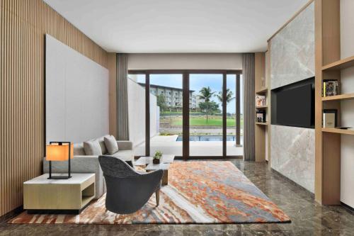 a living room with a couch and a tv at JW Marriott Hotel Bengaluru Prestige Golfshire Resort & Spa in Bengaluru
