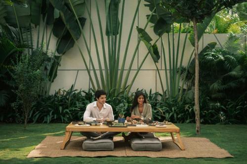 a man and woman sitting at a table at JW Marriott Hotel Bengaluru Prestige Golfshire Resort & Spa in Bengaluru