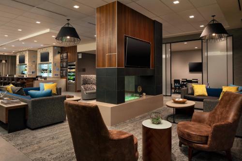 a lobby with couches and chairs and a television at Courtyard by Marriott Loveland Fort Collins in Loveland
