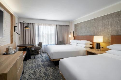 a hotel room with two beds and a desk at Sheraton Nashville Brentwood in Brentwood