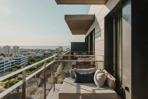 a balcony with a couch and a view of the city at Sabàtic Sitges Hotel, Autograph Collection in Sitges