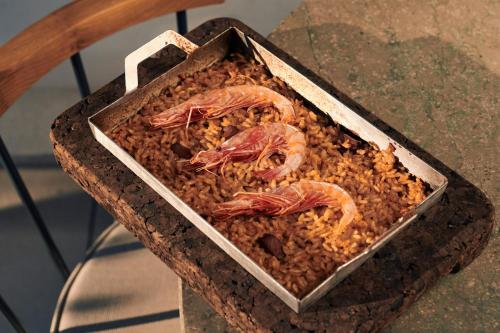 a container of food with shrimp on top of rice at Sabàtic Sitges Hotel, Autograph Collection in Sitges