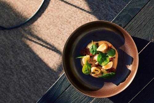 a bowl of food on a wooden table at Sabàtic Sitges Hotel, Autograph Collection in Sitges