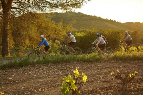a group of people riding bikes on a dirt road at Sabàtic Sitges Hotel, Autograph Collection in Sitges