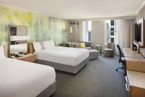 a hotel room with two beds and a desk at Courtyard Chicago Downtown/Magnificent Mile in Chicago