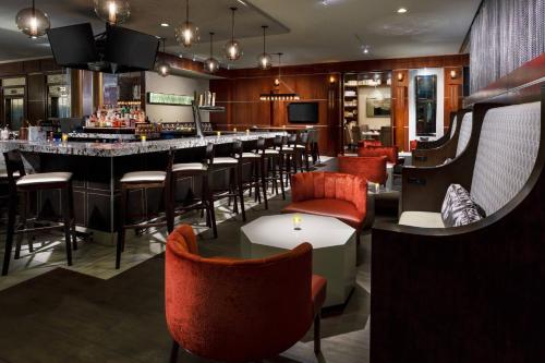 a restaurant with a bar with red chairs at Courtyard Chicago Downtown/Magnificent Mile in Chicago
