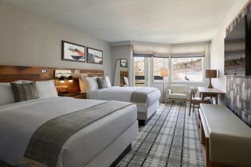 a hotel room with two beds and a couch at Viewline Resort Snowmass, Autograph Collection in Snowmass Village