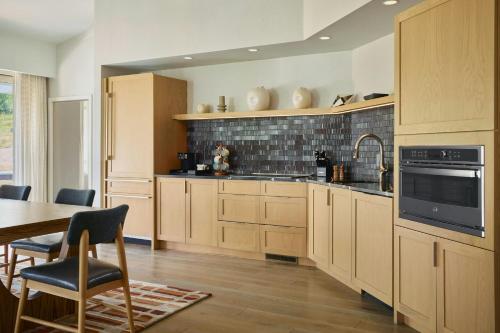a large kitchen with wooden cabinets and a table at Viewline Resort Snowmass, Autograph Collection in Snowmass Village