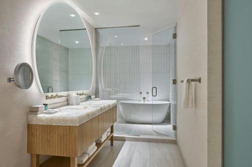a bathroom with two sinks and a tub and a mirror at Viewline Resort Snowmass, Autograph Collection in Snowmass Village