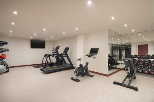 a gym with several exercise bikes and a mirror at The Welbeck Hotel by IHG in London
