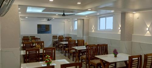 a restaurant with tables and chairs in a room at Cochin Airport Hotel in Ernakulam