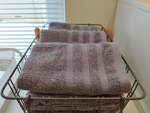 a metal basket with four towels on it at Soen 1996 Villa in Sapporo