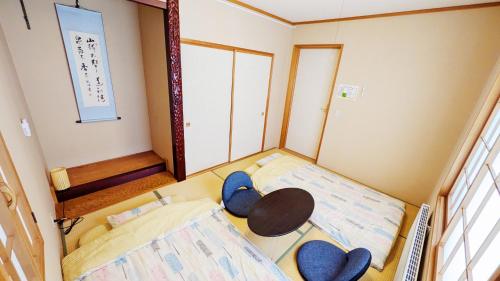 a small room with two beds and a table at Soen 1996 Villa in Sapporo