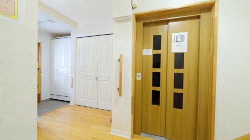 a hallway with a wooden door with a sign on it at Soen 1996 Villa in Sapporo