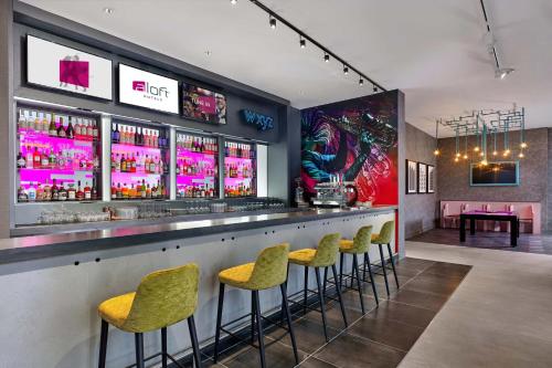 a bar with green stools in a restaurant at Aloft Birmingham Eastside in Birmingham