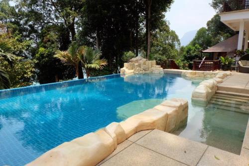 a large swimming pool with blue water at Hidden Paradise Private Master Bedroom Villa,Langkawi in Teluk Datai