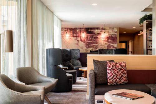 a lobby with chairs and a couch and a table at Courtyard Chicago O'Hare in Des Plaines