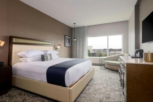 a hotel room with a large bed and a kitchen at The Stella Hotel, Autograph Collection in Bryan
