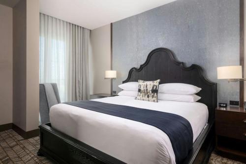a bedroom with a large bed with white sheets and pillows at The Stella Hotel, Autograph Collection in Bryan