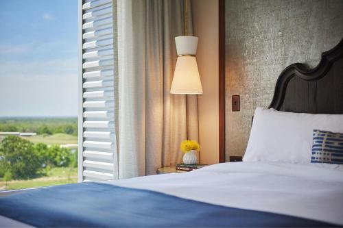 a bedroom with a bed and a large window at The Stella Hotel, Autograph Collection in Bryan