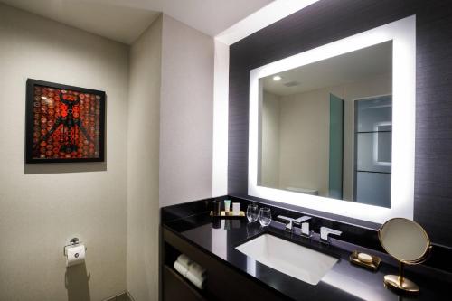 a bathroom with a sink and a large mirror at Hotel Vin, Autograph Collection in Grapevine
