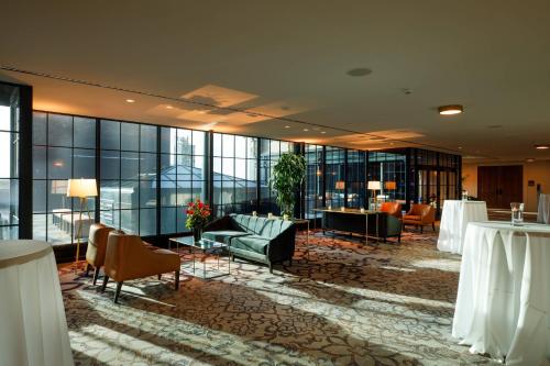 a hotel lobby with chairs and tables and windows at Hotel Vin, Autograph Collection in Grapevine