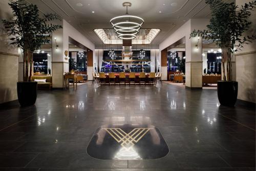 a lobby with a restaurant with a table and chairs at Hotel Vin, Autograph Collection in Grapevine