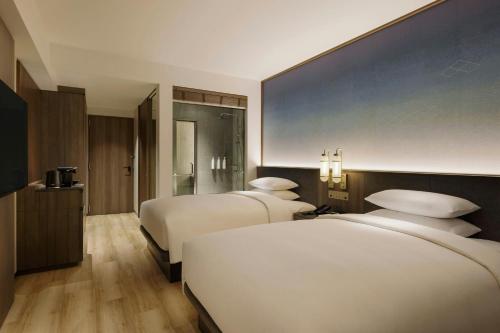 a hotel room with two beds and a blue wall at Courtyard by Marriott Fukui in Fukui