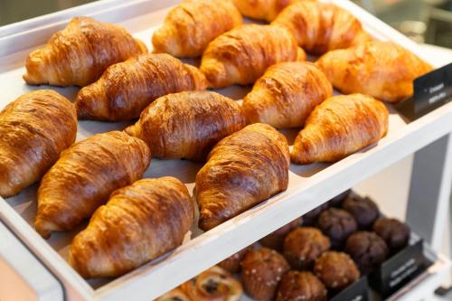 a display case filled with lots of croissants and other baked goods at Courtyard by Marriott Fukui in Fukui