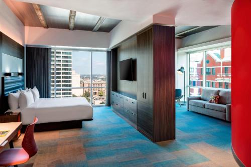 a hotel room with a bed and a large window at Aloft Fort Worth Downtown in Fort Worth