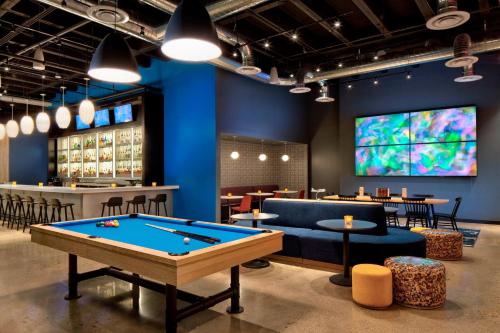 a room with a pool table and a tv at Aloft Fort Worth Downtown in Fort Worth