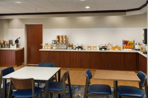 a waiting room with tables and chairs and a counter at Fairfield by Marriott Inn & Suites Las Vegas Stadium Area in Las Vegas
