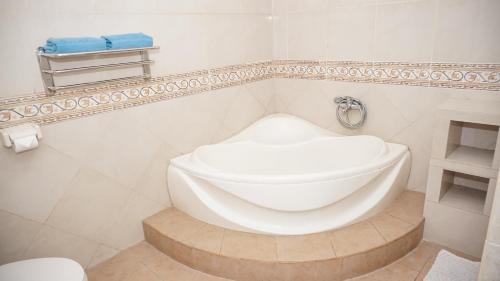 a white bathroom with a toilet and a sink at Villa Venetys Lembang by BWB in Cikidang 1