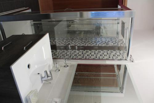 a glass cabinet with a sink in a room at Albergo Paradiso in Maccagno con Pino e Veddasca